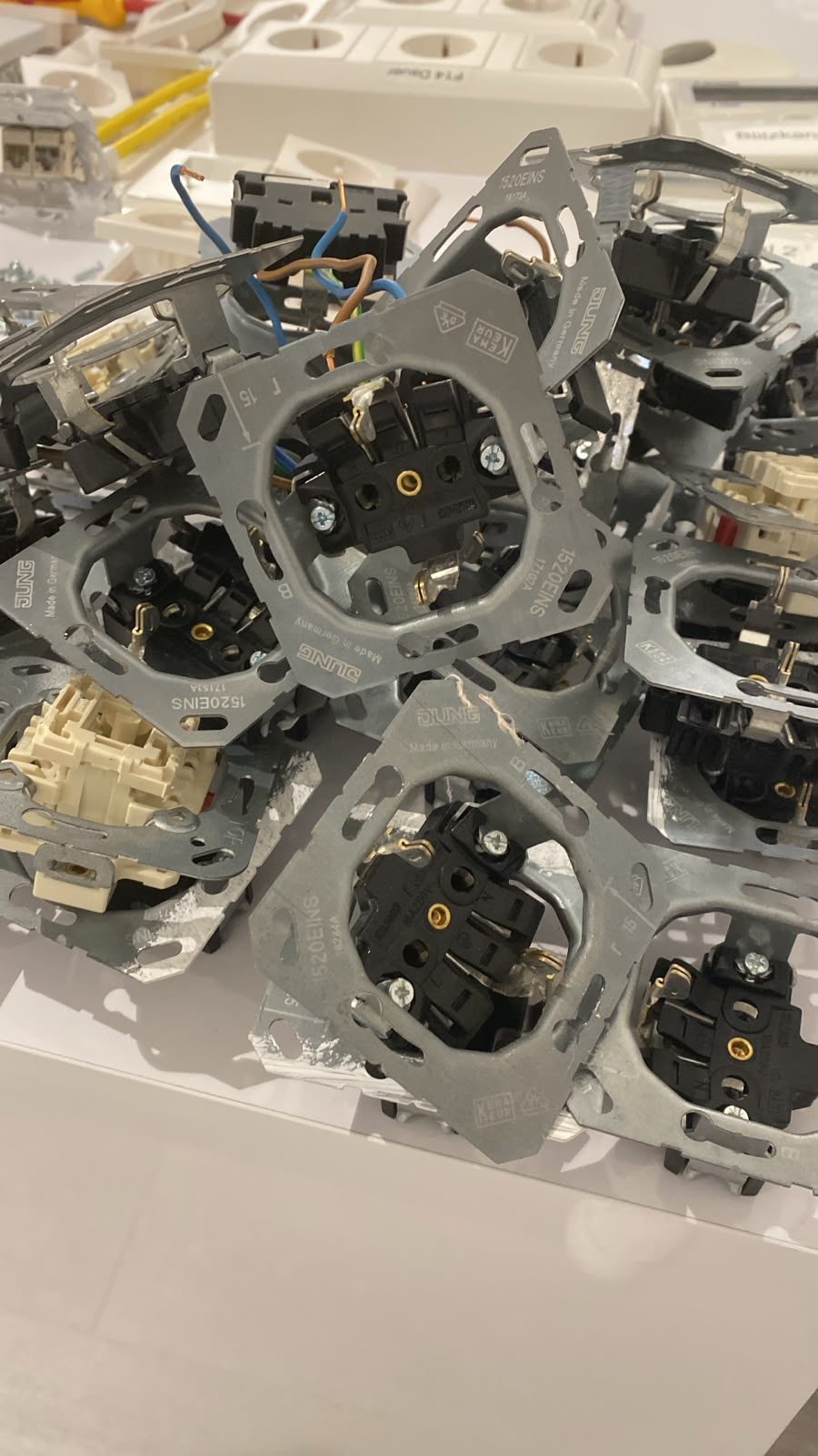 Ausgebaute alte Schalter und Steckdosen auf einem Tisch – Elektroarbeiten beim Umbau des neuen Natural Studios Standorts in Dresden